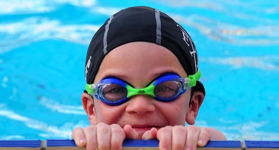 A member of the swim school smiling in the swimming pool.