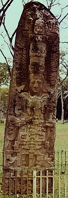 A tall, narrow monument with the prominent sculpture of a king surrounded by elaborate decoration