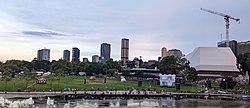 Adelaide City Skyline during 2022 Australia Day Celebrations Forefront: Torrens River, Elder Bank and Riverbank Precinct. From Right to Left: Stanford Hotel, Convention Centre, Myer Centre, The Switch, Realm Adelaide, Frome Central Tower One, GSA North Terrace, Schulz Building (Adelaide University).