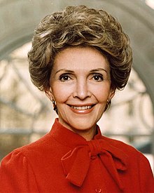 A smiling Reagan, a middle-aged woman with short hair, faces the camera.