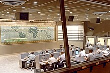 A look inside the Mercury Control Center, Cape Canaveral, Florida. Dominated by the control board showing the position of the spacecraft above ground