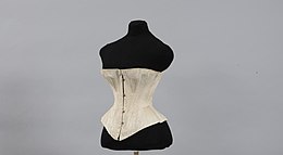 Un corset beige écru sur un mannequin noir avec une taille visiblement affinée