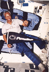 Guion S. Bluford, Jr. ombord på Discovery under uppdraget STS-53, hållande en flagga för Pennsylvania State University.