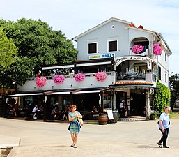 Konoba i turisti sa zapadne strane luke