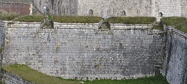 Embrasures ménagées dans des parapets de la citadelle de Besançon. Vue côté intérieur sur le bastion au premier plan et extérieure sur la fausse braie jouxtant le pont dormant et le bastion au second plan.