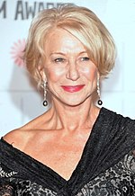 A woman in her late sixties is seen wearing a black dress and earrings.