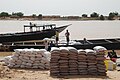 Flusshafen in Kaédi in Mauretanien. Die dunklen Säcke rechts enthalten brasilianischen Rohrzucker, der in den Senegal transportiert wird, die weißen Säcke mit senegalesischem Mais werden eingeführt.