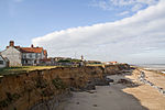 The precarious position of houses due to the effects of coastal erosion