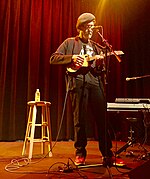 Country music singer Jon Vezner, singing while playing an acoustic guitar