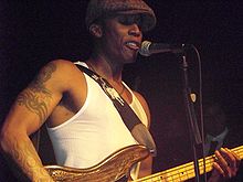 Saadiq playing bass guitar onstage