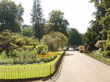 Photo. Allée bordée de massifs de fleurs et de bosquets