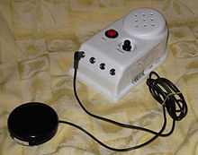 a small electronic device with several buttons, there is a cable going from the device to an activation button.