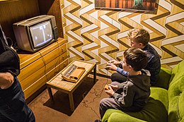 Two children playing Pong on a television set.