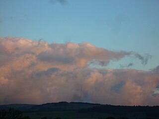 Stratocumulus stratiformis and small castellanus made orange by the sun rising