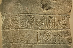 Fragment stele z napisom, ki se bere z desne in se glasi: "Ur-Nanše / kralj / Lagaša / sin Guniduja / (bogu) Ningirsuju..." (Louvre)