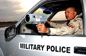 Un policier militaire utilisant un pistolet radar pour mesurer la vitesse des automobiles sur la base aérienne de Tallil, Irak.