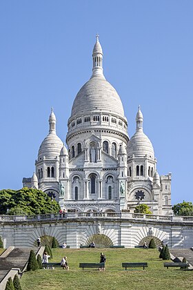 Les escaliers du square Louise-Michel mènent à la basilique connue pour son porche à trois arches et à deux étages, son grand dôme circulaire entouré de quatre petits dômes octogonaux sommés de lanternons et flanqués de tourelles.