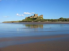 Photo d'un château situé sur un promontoire rocheux surmontant la mer.