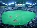 Estadioaren barruan beisbol partida batean.