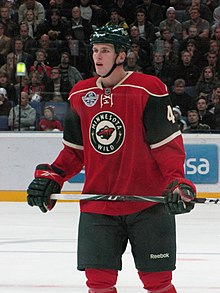 Photographie de Justin Falk avec le maillot rouge du Wild.