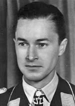 Black-and-white photograph showing the face and shoulders of a young man in uniform. The front of his shirt collar bears an Iron Cross decorations, black with light outline.