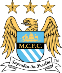 A badge depicting a shield with an eagle behind it. On the shield is a picture of a ship, the initials M.C.F.C. and three diagonal stripes. Below the shield is a ribbon with the motto "Superbia in Proelia". Above the eagle are three stars.