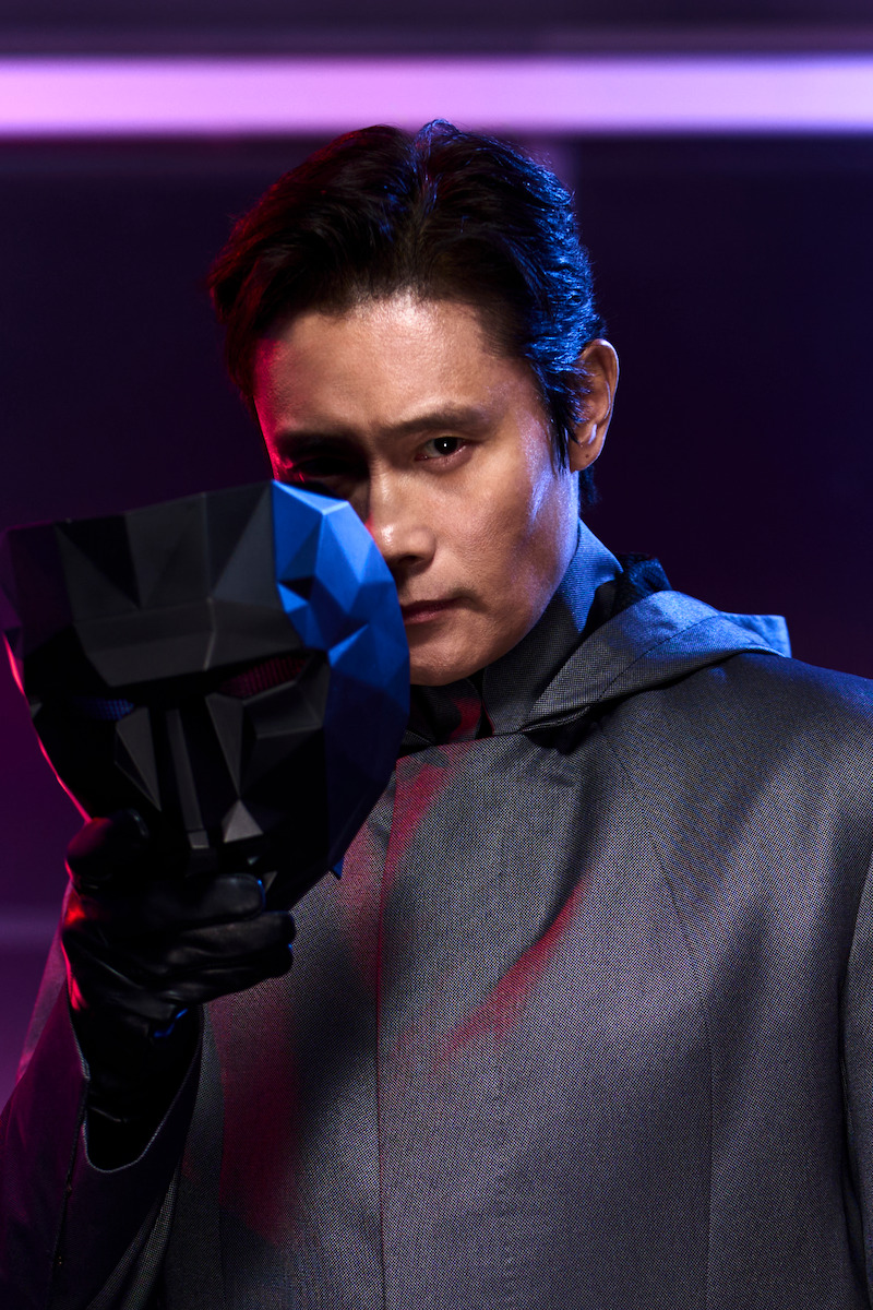 Lee Byung-hun as Front Man holds a black mask close to his face in 'Squid Game' Season 2 