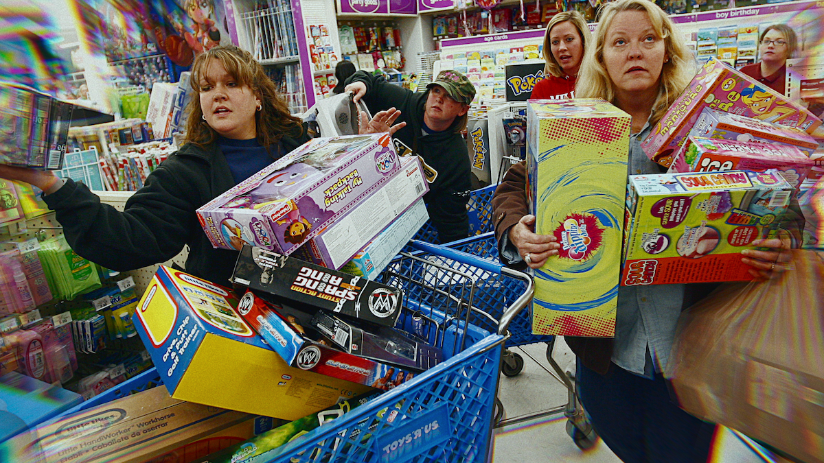 People loading shopping carts in a toy store.