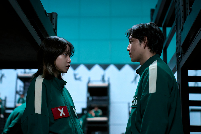 Jo Yu-ri as Kim Jun-hee and Yim Si-wan as Lee Myung-gi wear green sweat suits in 'Squid Game' Season 2