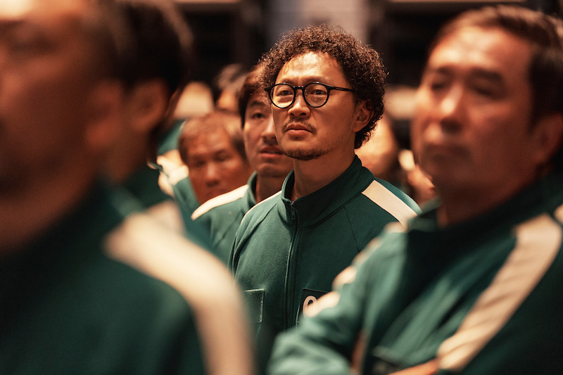 Yang Dong-geun as Park Yong-sik stands in a crowd of players in 'Squid Game' Season 2 