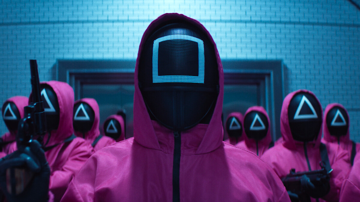 A group of people in pink hooded jumpsuits and masks gathered in Season 2 of 'Squid Game'