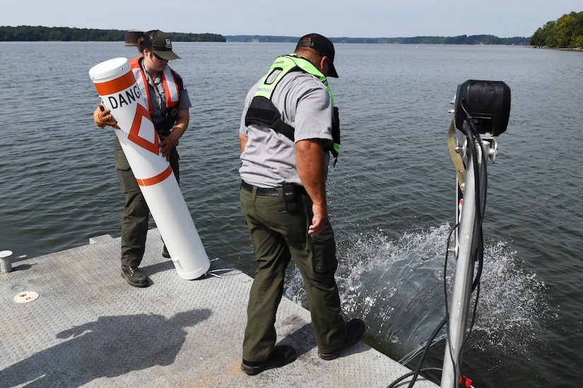 U.S. Army Corps of Engineers Ranger David Landis (right)  drops a buoy anchor into the water as Ranger Intern Philicady Carland prepares to drop the buoy in after it at Lake Barkley in Kuttawa, Kentucy, Aug. 14, 2024.