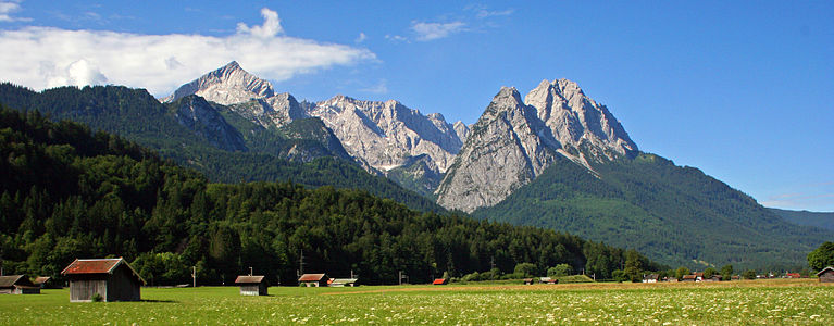 With green meadow. Mountains from left: Alpspitze, Jubiläumsgrat above valley Höllental, Mandl with Waxenstein peaks and without that peak of Zugspitze