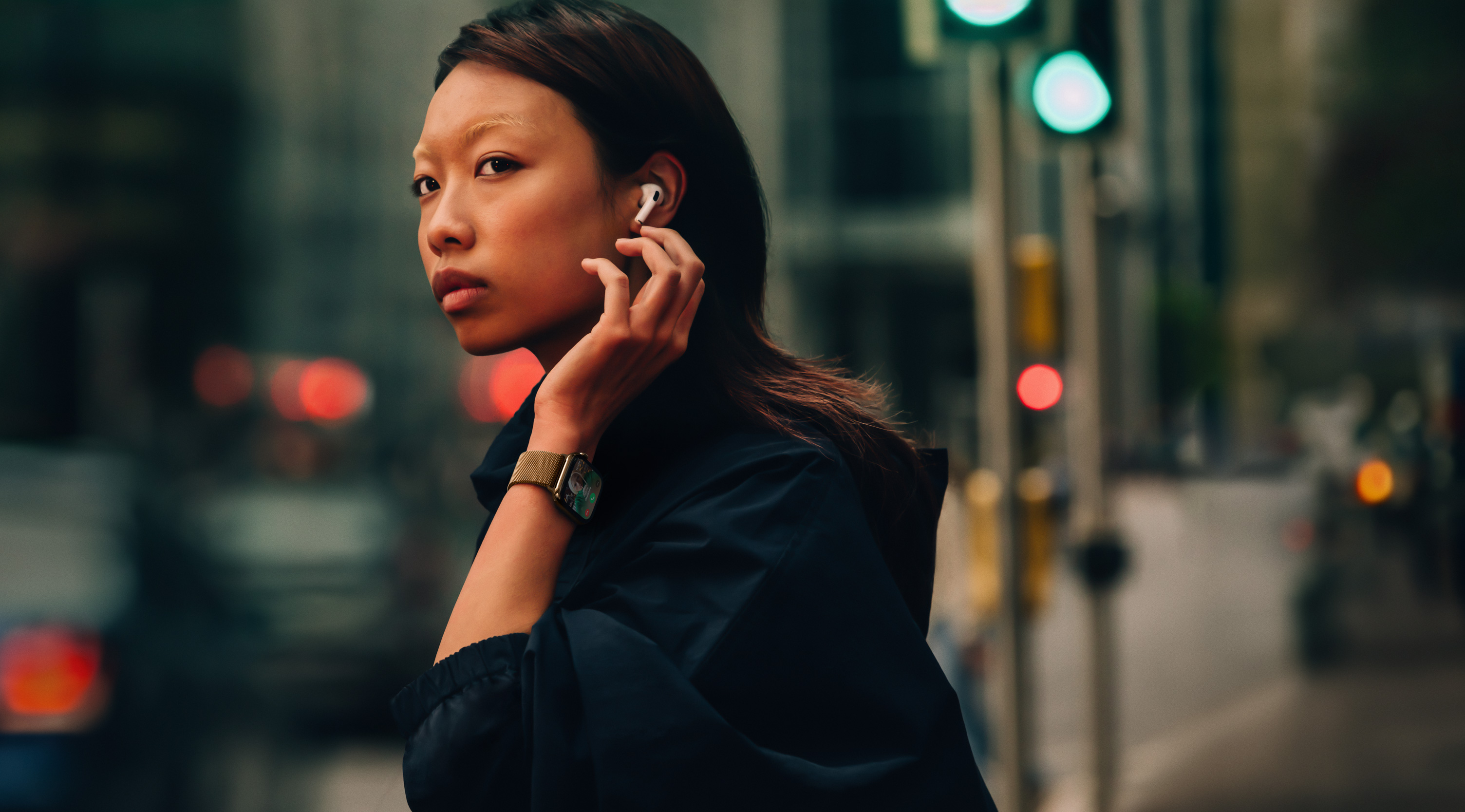 En kvinne i en gate har på seg Apple Watch Series 10 og AirPods i ørene.