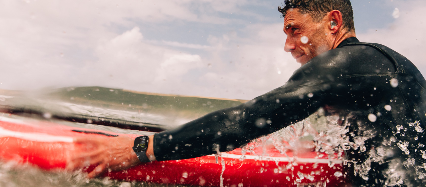 A man with a paddle board in the water wearing Apple Watch Series 10.