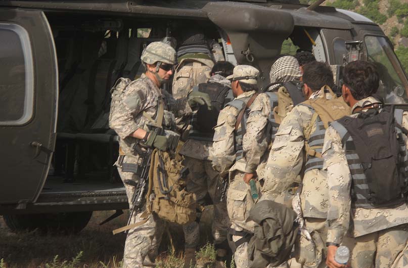 Capt. William Swenson leads Afghan Border Police members as they board a UH-60 Black Hawk helicopter, May 2009.