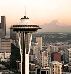 Aerial view of Space Needle with mountains in the background located in downtown Seattle, Washington. Captain Swenson holds a Bachelor of Science in Political Science from Seattle University. Photo courtesy of Seattle Municipal Archives.