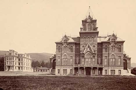 Historic black and white photo of the facade of large building.