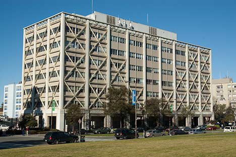 Building with large crossed windows and cars on street