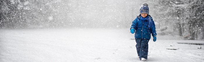 Boy walking in snow. 