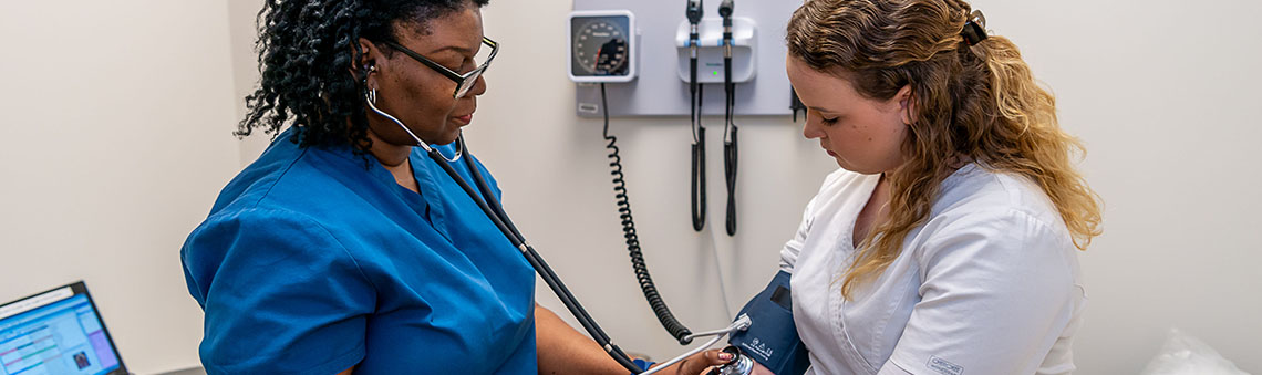 two medical assistant students working in a mock lab