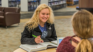 Student smiling working on homework