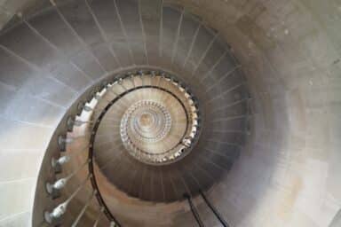 A spiral staircase winds upward and upward, symbolizing the steps for learning how to stop worrying.