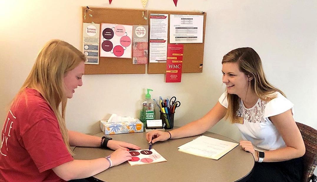 Two people seated at a table for an academic coaching session