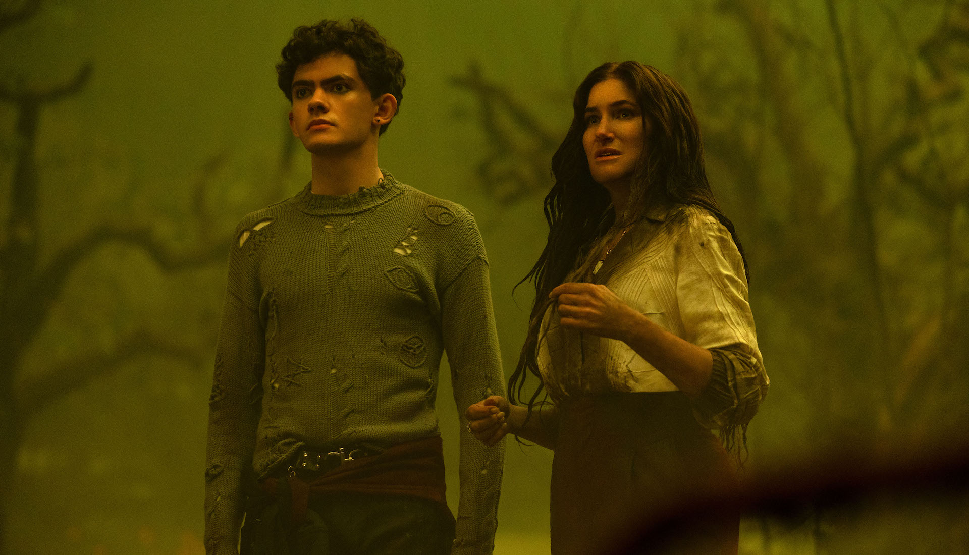 An adult woman and a teen standing in a dark, green-hued swampy setting; still from 'Agatha All Along'