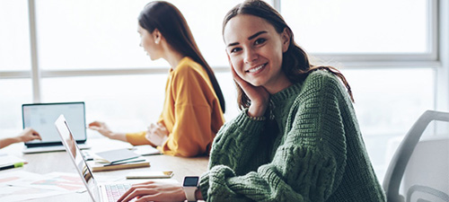 Photo of two students with laptops