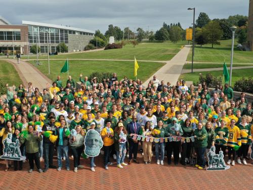 Members of the campus community wearing green and gold