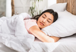 Relaxed Girl Sleeping Comfortably in Bed At Home.