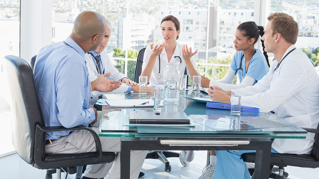 A group of nurses sitting at a table together having a meeting