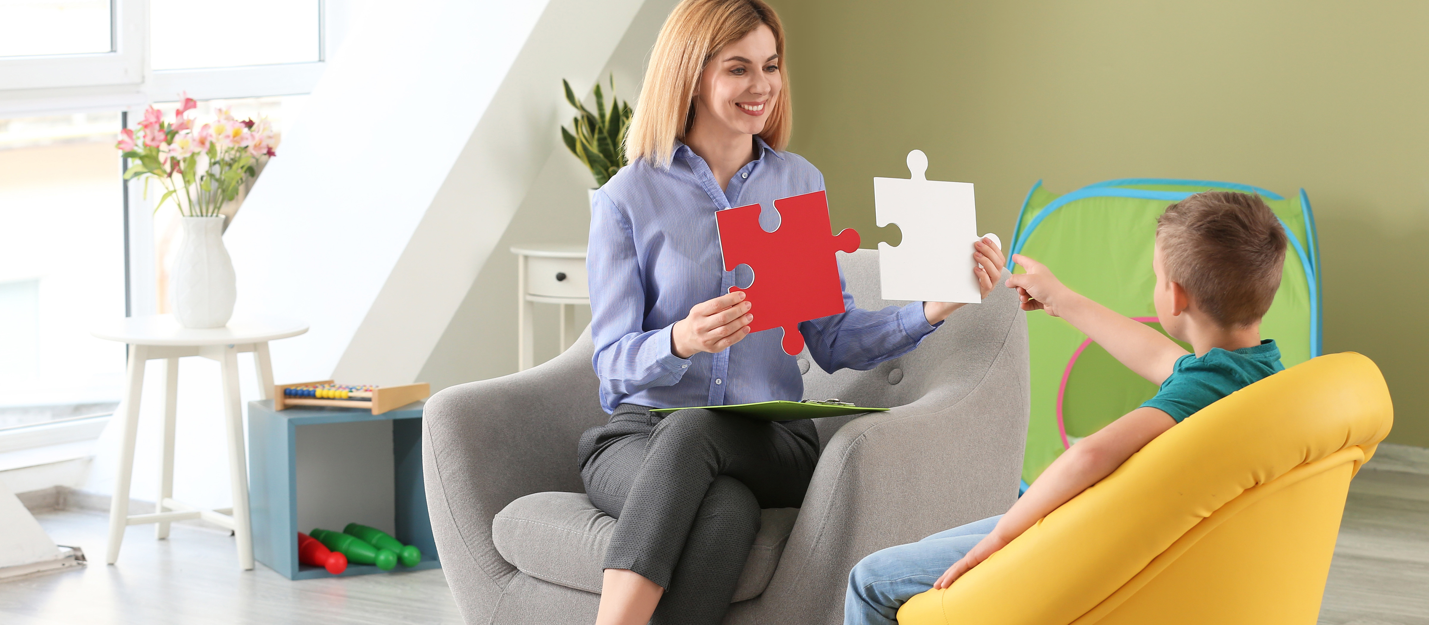 woman showing a child large puzzle pieces 